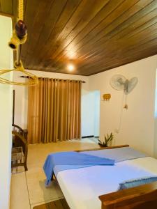 a bedroom with a bed with a wooden ceiling at Rasara Home Stay in Ahangama