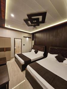 a hotel room with two beds and a tv at Chhaya Niketan Home Stay in Ayodhya +30 photos