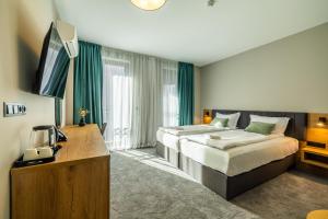 a bedroom with a bed and a desk and a television at Acacia Hotel in Sofia +96 photos
