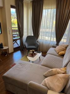 un soggiorno con un divano e una sedia di Vesta Boutique Apartment a Bansko