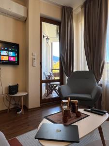 un soggiorno con una sedia e un tavolo di Vesta Boutique Apartment a Bansko