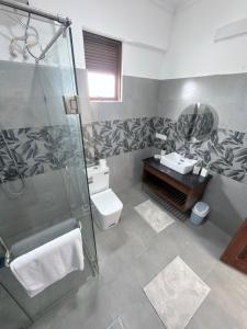 a bathroom with a shower and a toilet and a sink at The Altura Apartment in Mount Lavinia +14 photos