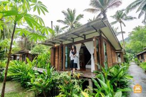 a woman standing in the doorway of a tiny house at Jungle Koh Kood Resort in Ko Kood