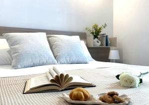 a bed with an open book and two donuts on it at Residence Le Sirene in Termoli