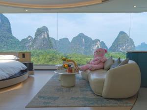 a room with a couch with a teddy bear on it at 桂林阳朔良宿 LS Hotel Liangsu Yangshuo in Gaotian