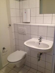 a white bathroom with a toilet and a sink at Ferienwohnung Annelie in Zinnowitz