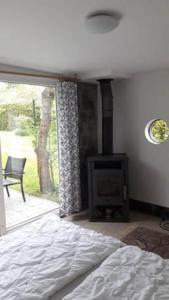 1 dormitorio con 1 cama, chimenea y ventana en Ferienhaus Ralf, en Zinnowitz