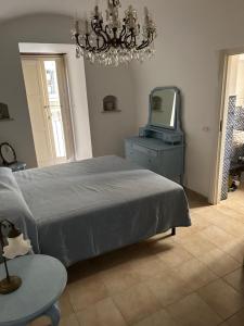 a bedroom with a bed and a tv and a chandelier at Appartamento Bellezza Orsini in Benevento