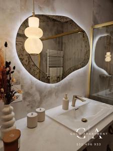 a bathroom with a sink and a mirror at Gold Apartment E54 Let's Sea Baltic Park Gąski in Gąski