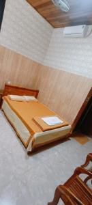 a small bed in a room with a wooden floor at Van tan in Kon Plong