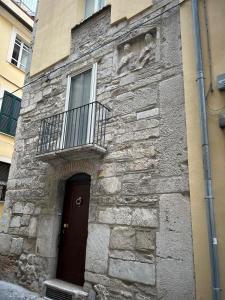 a stone building with a door and a balcony at Appartamento Bellezza Orsini in Benevento +2 photos
