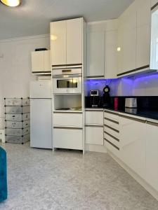 a white kitchen with white cabinets and appliances at Peaceful Holiday Home with a Touch of Comfort in San Miguel de Salinas