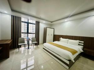 a hotel room with a large bed and a table at Crowne Plaza Hotel in Bắc Ninh