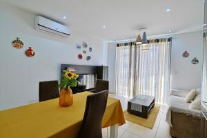 a dining room with a yellow table and chairs at Central 2 Bed Apartment in Gwardamanġa