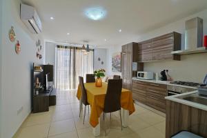 a kitchen with a table and chairs in a kitchen at Central 2 Bed Apartment in Gwardamanġa