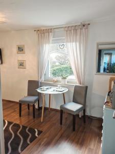 d'une salle à manger avec une table, deux chaises et une fenêtre. dans l'établissement Privates Zimmer mit eigenem Bad in Hochdorf-Assenheim, à Hochdorf-Assenheim