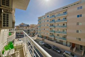 a balcony of a building with cars parked on a street at Central 2 Bed Apartment in Gwardamanġa