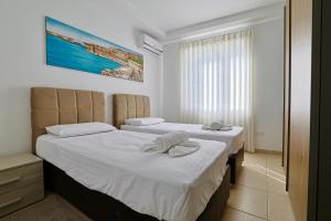two beds in a hotel room with towels on them at Central 2 Bed Apartment in Gwardamanġa