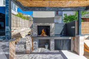 een buitenkeuken met een open haard in de achtertuin bij Villa Eden Adults Only in Trogir