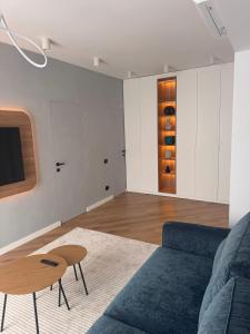 a living room with a blue couch and a table at CHANTTAL Luxury - ACADEMY in Bucharest