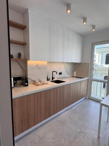 a kitchen with white cabinets and a counter top at CHANTTAL Luxury - ACADEMY in Bucharest