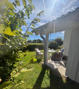 a patio with two chairs and a pergola at Chiemsee Häuschen in Prien am Chiemsee +18 photos