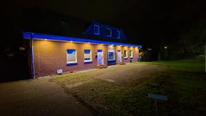 a brick building with blue lights on it at night at 90m Apartment 5 Schlafplätze in Tostedt