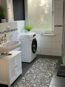 a bathroom with a washing machine and a sink at 90m Apartment 5 Schlafplätze in Tostedt +12 photos