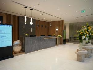 a lobby of a hotel with a reception desk and flowers at Novotel Riyadh Al Anoud in Riyadh