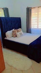 a bed with pillows on it in a room at Zion Apartment Diani in Diani Beach +9 photos