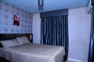 a bedroom with a bed and a window with a curtain at Villa 29 in Enugu