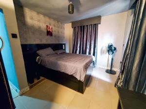 a bedroom with a bed in a room with a fan at Villa 29 in Enugu