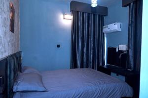 a small bedroom with a bed and a window at Villa 29 in Enugu +2 photos