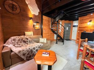 een woonkamer met een bank en een wenteltrap bij Le Douillet des Pyrénées, Luxury Chalet Home in Ax-les-Thermes