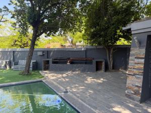 a backyard with a swimming pool and a building at UbuntuLifeStyleEstate-Premium Suite in Krugersdorp