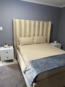 a bed with a large headboard in a bedroom at UbuntuLifeStyleEstate-Premium Suite in Krugersdorp +46 photos