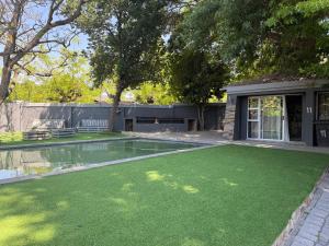 a backyard with a pool with green grass at UbuntuLifeStyleEstate-Premium Suite in Krugersdorp