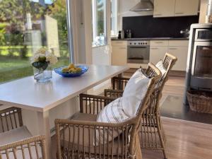 a kitchen with a table and chairs with a bowl of fruit at Chiemsee Häuschen in Prien am Chiemsee