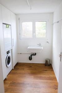 a bathroom with a sink and a washing machine at Ferienhaus Mostelrain in Sattel +17 photos