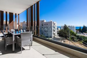 Pearl Beach Luxury Family Suite في ليماسول: شرفة مع طاولة وكراسي وإطلالة على المدينة