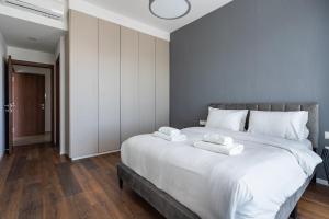 Pearl Beach Luxury Family Suite في ليماسول: غرفة نوم بها سرير كبير عليه منشفتين