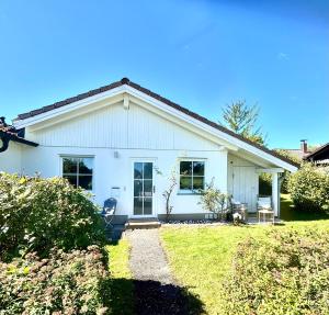 基姆湖畔普林Chiemsee Häuschen的院子里的白色房子,带两把椅子