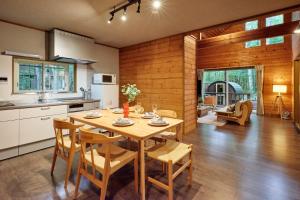 a kitchen and dining room with a table and chairs at Villa Noël Kitakaruizawa Jardin Forest Sauna Hideaway in Tsumagoi