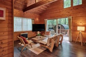 a living room with a fireplace and a television in a log cabin at Villa Noël Kitakaruizawa Jardin Forest Sauna Hideaway in Tsumagoi