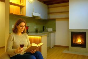 にあるCasa da Ildaの本を読みワインを飲む女