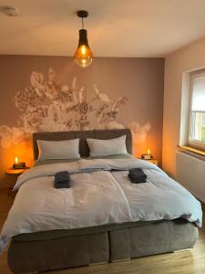 a bedroom with a large bed with a painting on the wall at Ferienwohnung Clemens in Ediger-Eller