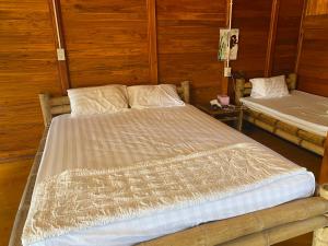 Ấp Thiện SơnTree house的一间木墙房间里的一张大床