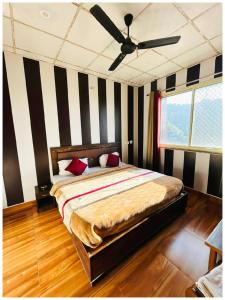 une chambre avec un lit et un ventilateur de plafond dans l'établissement Mountain Valley View Maya Hotel Near The Mall Road - Free Parking - Restaurant Facilities - Hygiene and Spacious Room - The Best Mountain Views Hotel In Mussoorie, à Mussoorie