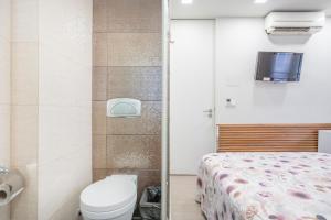 a bathroom with a bed and a toilet and a tv at Souto Centro Rooms in Braga