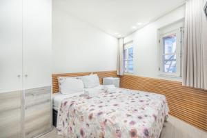 a bedroom with a bed and two windows at Souto Centro Rooms in Braga